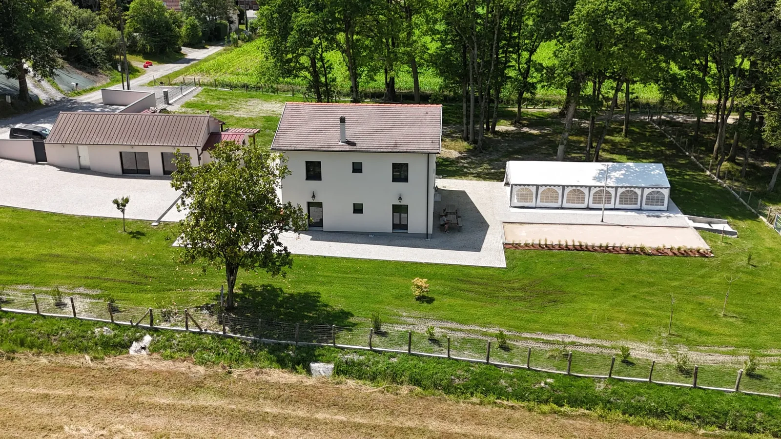 La maison et la tente de réception entourées d’arbres