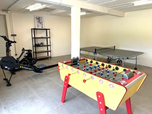 Salle de jeux avec baby-foot, ping-pong et appareils de sport