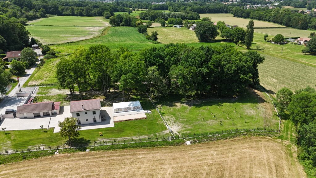 Le domaine entouré de ses grands arbres et de la campagne